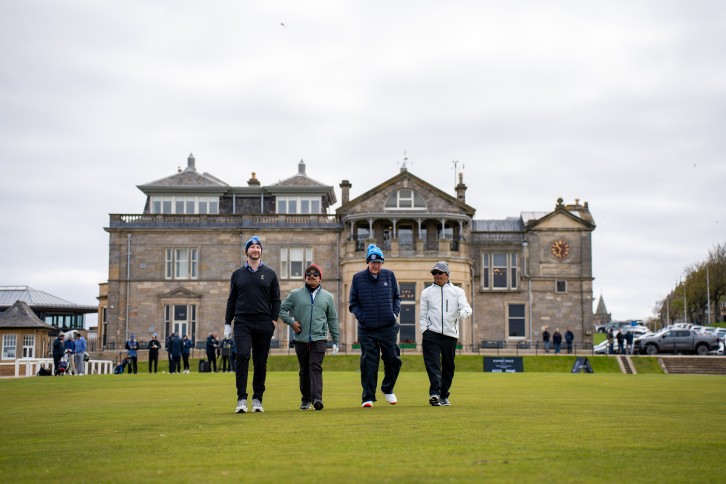A fourball walking off the 1st tee of the Old Course in front of the R&A clubhouse