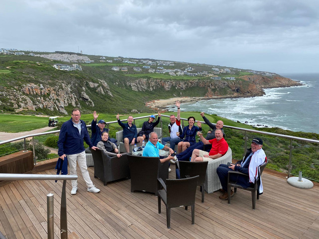 Group dining on a terrace overlooking the coast